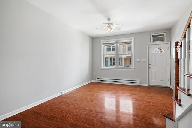 entrance foyer featuring baseboard heating, a wall mounted air conditioner, stairway, wood finished floors, and ceiling fan