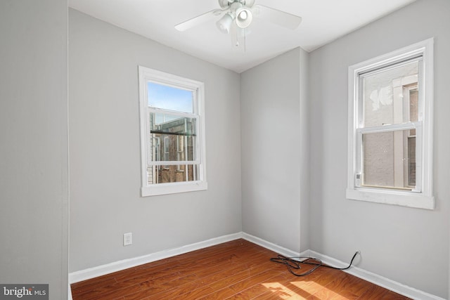 spare room featuring wood finished floors, baseboards, and ceiling fan