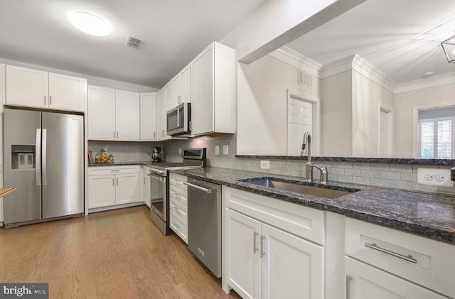 20620 Hope Spring Ter Unit 206, Ashburn, VA 20147 - kitchen with appliances with stainless steel finishes, a sink, dark stone counters, white cabinetry, and decorative backsplash