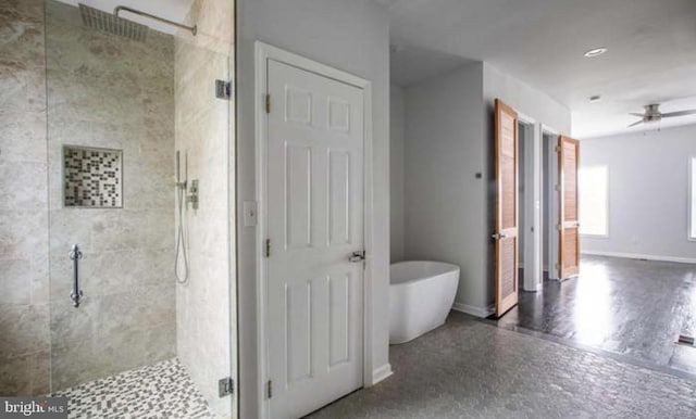 bathroom featuring ceiling fan, a freestanding bath, baseboards, and a stall shower