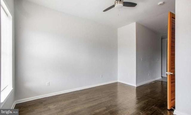 empty room with baseboards, ceiling fan, and wood finished floors