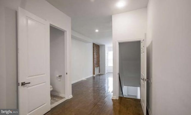 corridor with baseboards, recessed lighting, and wood finished floors