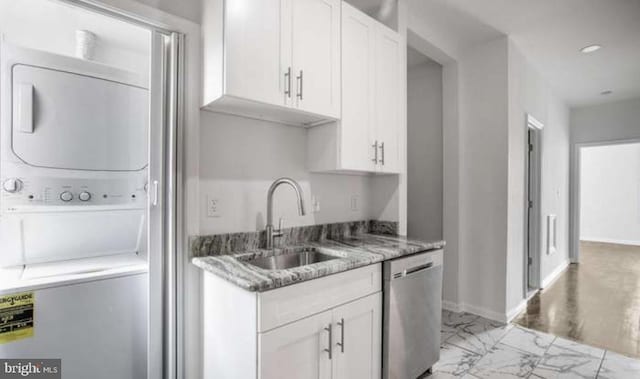 kitchen with dishwasher, stacked washing maching and dryer, a sink, white cabinets, and marble finish floor