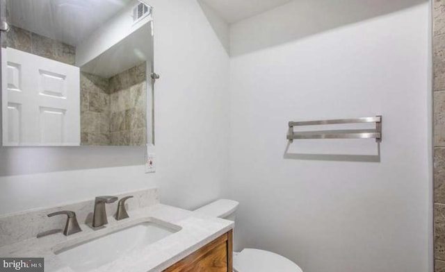 full bath with vanity, toilet, and tiled shower
