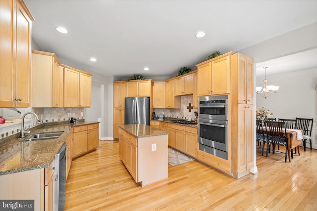 kitchen featuring light brown cabinetry, appliances with stainless steel finishes, and a sink