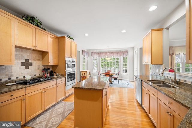 kitchen featuring a sink, appliances with stainless steel finishes, plenty of natural light, and light wood-style floors