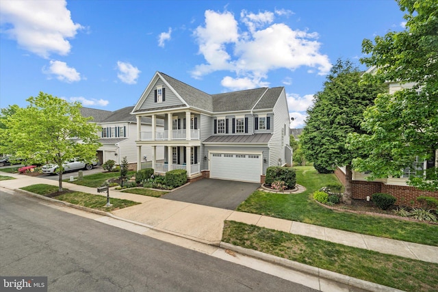 view of front facade featuring roof with shingles, an attached garage, a front lawn, aphalt driveway, and a balcony