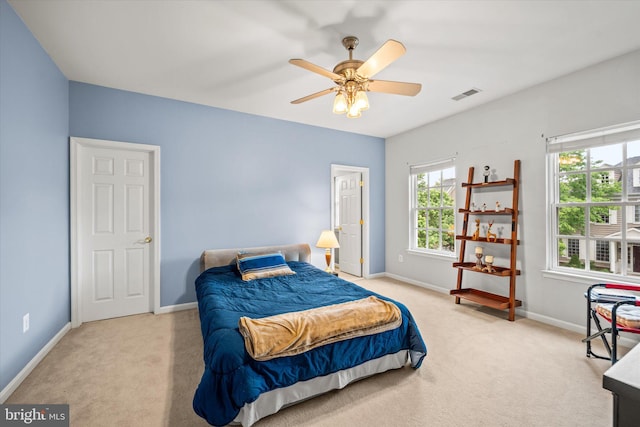 carpeted bedroom featuring baseboards, visible vents, and ceiling fan