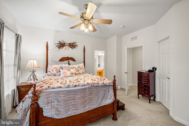 bedroom with a ceiling fan, visible vents, baseboards, connected bathroom, and light carpet