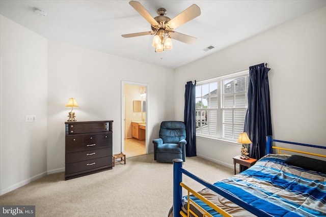 carpeted bedroom with visible vents, connected bathroom, baseboards, and ceiling fan