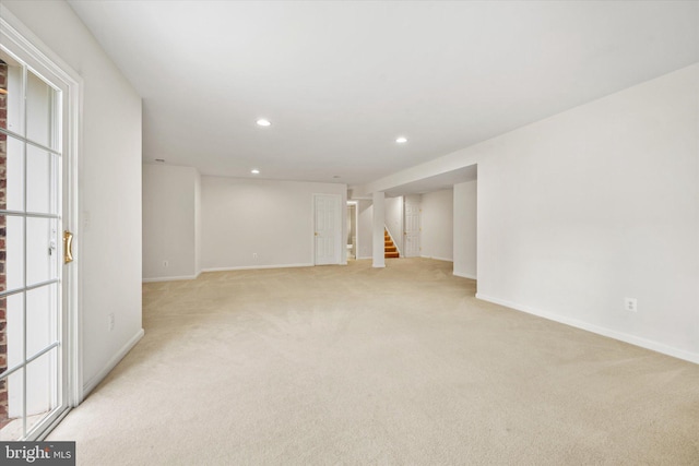 finished basement with stairway, baseboards, recessed lighting, and light colored carpet