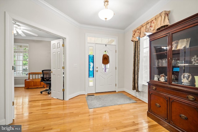 foyer featuring light wood-style floors, a ceiling fan, baseboards, and crown molding
