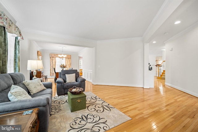 living room featuring crown molding, a notable chandelier, and light wood-style floors
