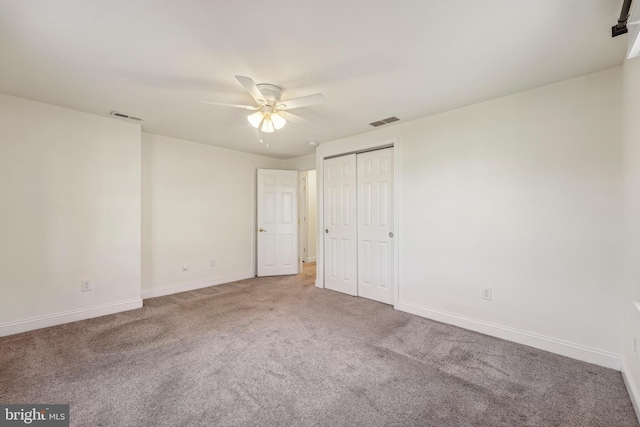 unfurnished bedroom featuring visible vents, baseboards, carpet floors, and ceiling fan