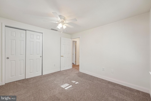 unfurnished bedroom featuring carpet flooring, baseboards, visible vents, and a closet