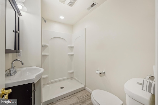 bathroom featuring vanity, a stall shower, toilet, and visible vents