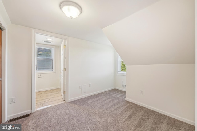 additional living space featuring carpet floors, baseboards, and visible vents