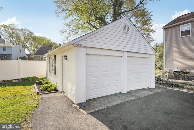 detached garage featuring fence