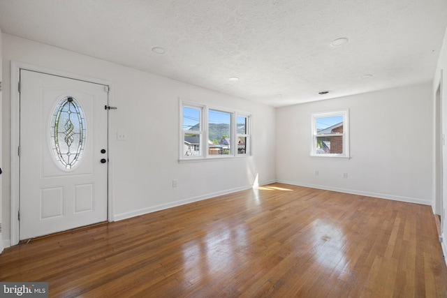 entrance foyer featuring hardwood / wood-style floors, baseboards, a textured ceiling, and recessed lighting