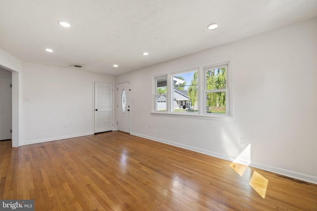interior space with recessed lighting, wood finished floors, and baseboards