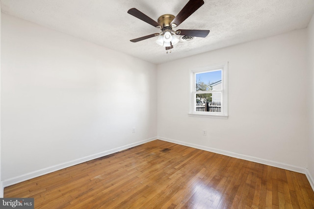 unfurnished room with wood finished floors, baseboards, a textured ceiling, and a ceiling fan