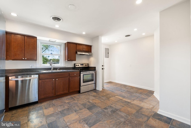 kitchen featuring under cabinet range hood, stainless steel appliances, dark countertops, visible vents, and a sink