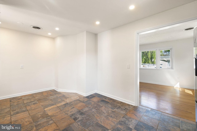 spare room featuring recessed lighting, visible vents, stone finish flooring, and baseboards