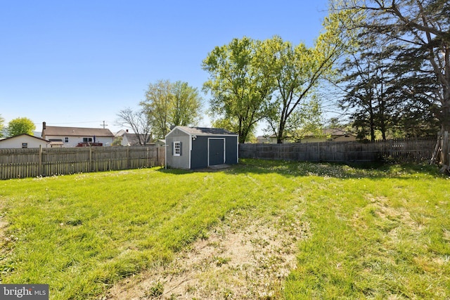 view of yard with a fenced backyard, an outbuilding, and a shed