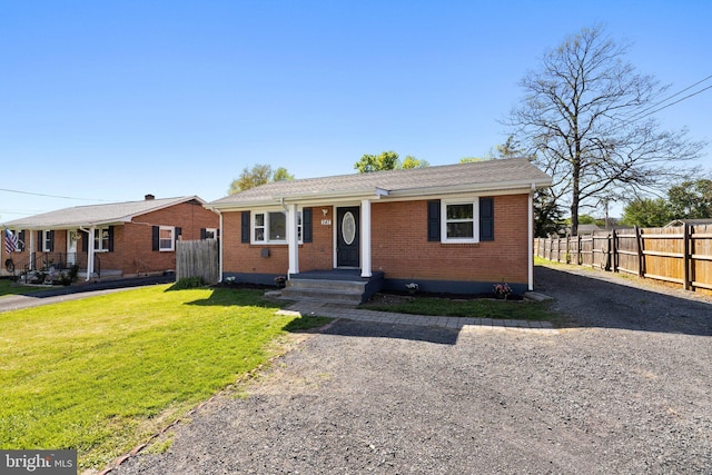view of front of home featuring brick siding, a front lawn, and fence