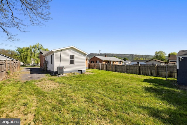 view of yard with a fenced backyard and central AC