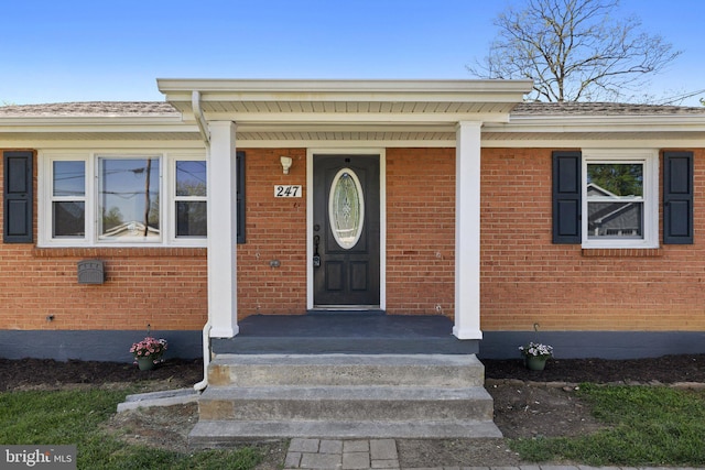 doorway to property with brick siding