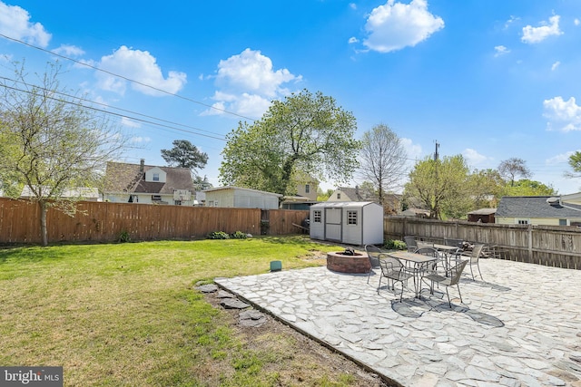 view of yard featuring an outdoor structure, a fenced backyard, a patio area, and a storage shed