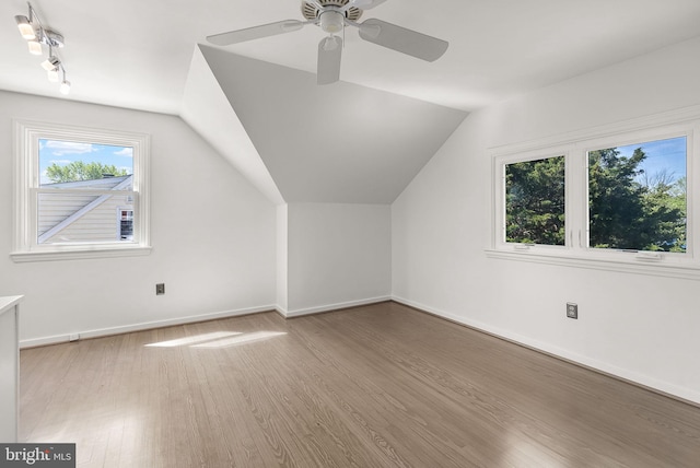 additional living space featuring a ceiling fan, baseboards, vaulted ceiling, and wood finished floors