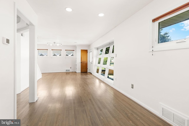 interior space featuring recessed lighting, baseboards, visible vents, and wood finished floors