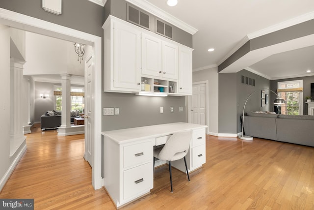 office space featuring ornate columns, built in study area, light wood-style flooring, baseboards, and crown molding