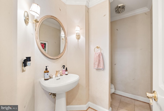 bathroom featuring ornamental molding, toilet, tile patterned flooring, and baseboards