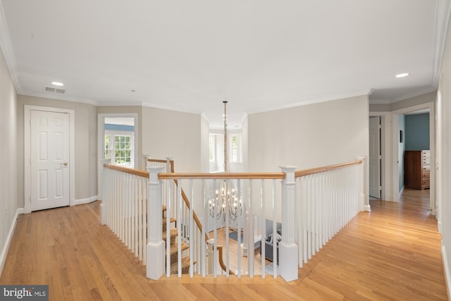 corridor featuring an upstairs landing, wood finished floors, a chandelier, crown molding, and recessed lighting