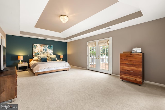 carpeted bedroom featuring a tray ceiling, access to exterior, baseboards, and french doors