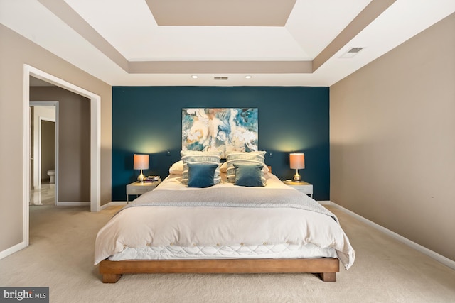 bedroom with carpet flooring, a tray ceiling, and baseboards