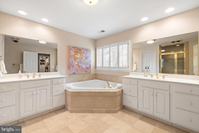 bathroom with a shower stall, two vanities, a garden tub, and tile patterned flooring