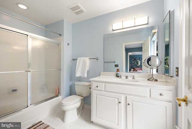 bathroom with toilet, tile patterned flooring, shower / bath combination with glass door, and vanity