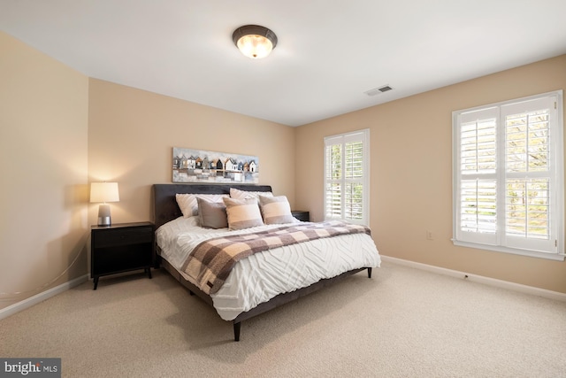 bedroom with light colored carpet and baseboards