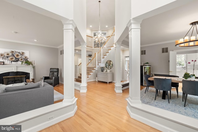 foyer entrance featuring a chandelier, light wood-style flooring, stairway, recessed lighting, and ornamental molding