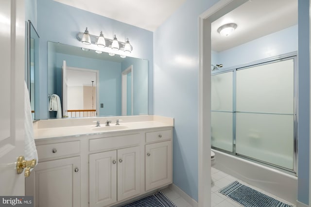 full bathroom with toilet, tile patterned floors, vanity, combined bath / shower with glass door, and baseboards