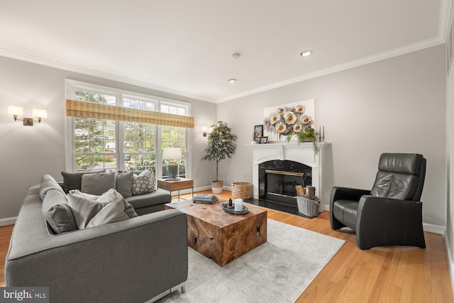 living room with ornamental molding, light wood-style flooring, a fireplace, baseboards, and recessed lighting