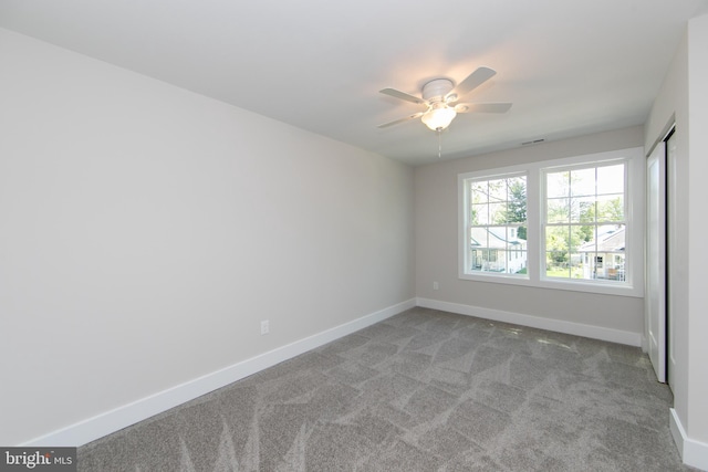 unfurnished room featuring a ceiling fan, visible vents, carpet floors, and baseboards