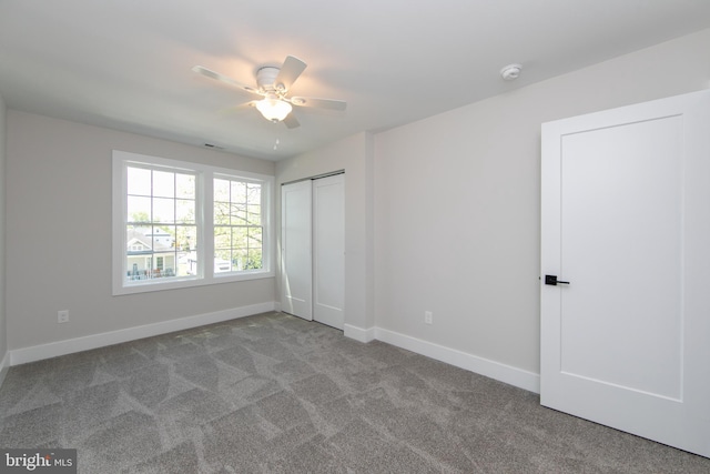 unfurnished bedroom with baseboards, ceiling fan, a closet, and carpet flooring
