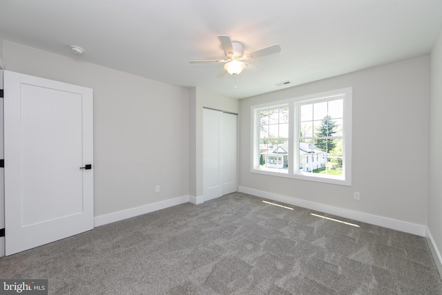 unfurnished bedroom with visible vents, a closet, carpet flooring, and baseboards