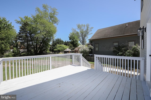 wooden terrace featuring fence and a yard