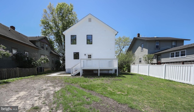 back of house with a lawn, a deck, and fence